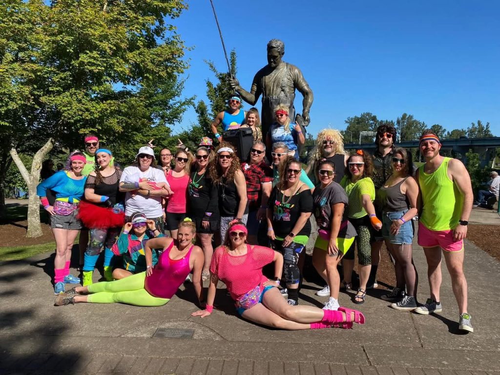 Crew in 80s neon gear and wigs
